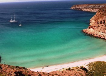 an isolated beach with two sailboats