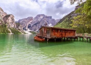 View of the boat house on the famous Lake Braies with emerald water in Italy