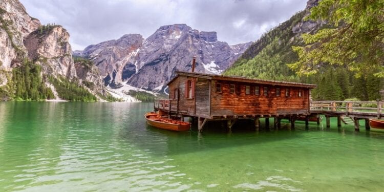 View of the boat house on the famous Lake Braies with emerald water in Italy