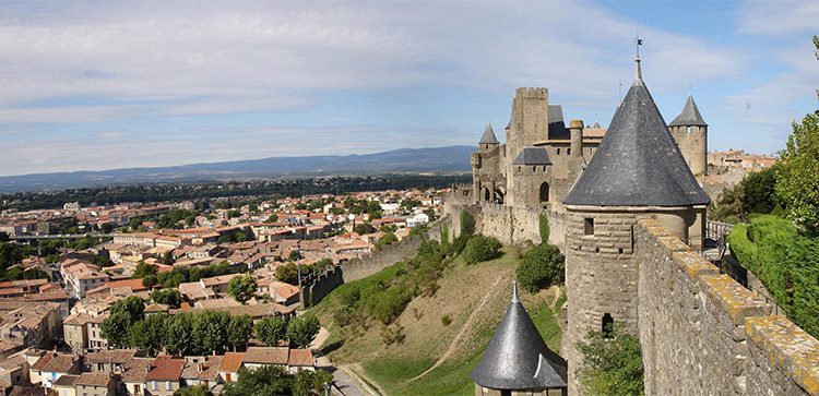 a stone wall and homes in carcassone france