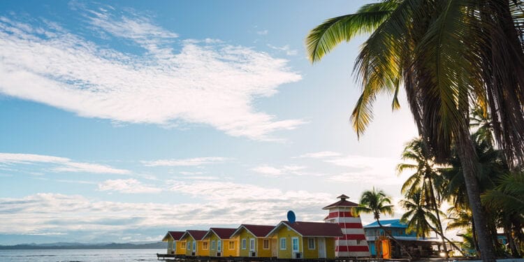 Picturesque view of small colorful houses on tropical coastline with palm trees, Panama.