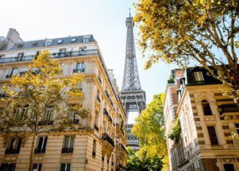 Beautiful street view with old residential buildings and Eiffel tower during the daylight in Paris