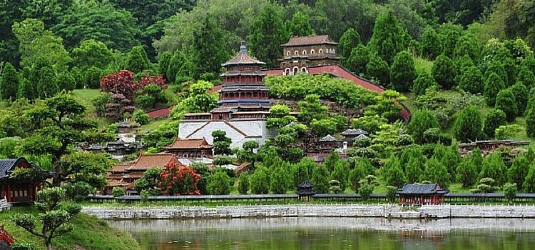 A hillside with a temple in China with water in front and