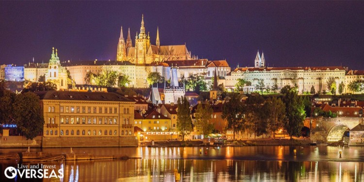the Prague skyline by the river lit up at night