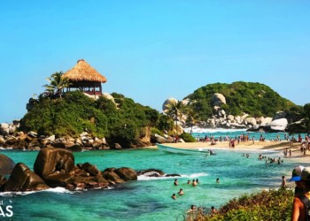 a popular beach with rocks and hills in colombia
