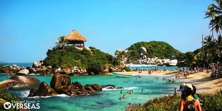 a popular beach with rocks and hills in colombia
