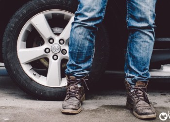a man wearing jeans and work boots standing in front of an suv. Bringing Your Car To Belize