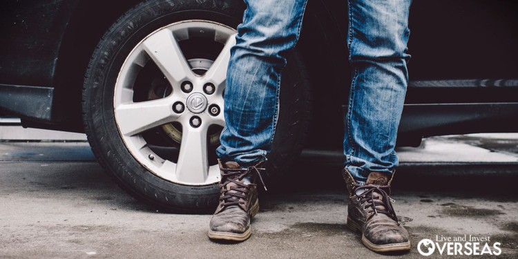 a man wearing jeans and work boots standing in front of an suv. Bringing Your Car To Belize