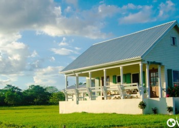 a small house with a porch on a large lot