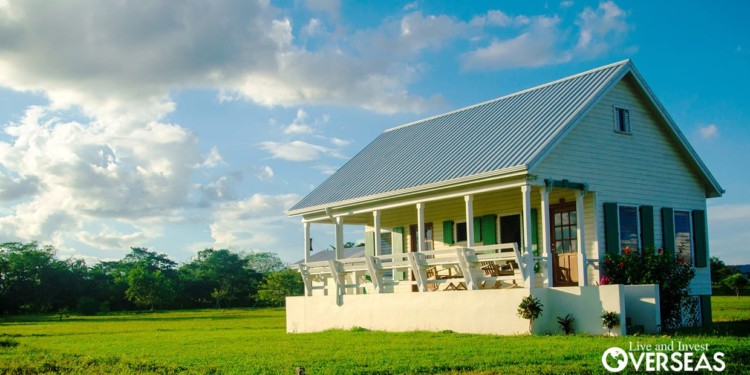 a small house with a porch on a large lot