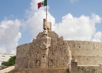 a stone monument with a mexican flag on top