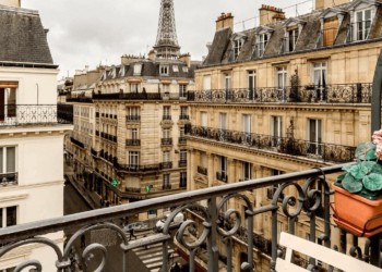 view of Paris apartment buildings from a balcony with a flowers