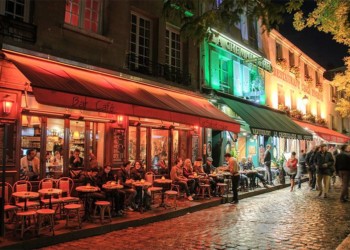 Busy cafes in montmartre lit by colorful street lights