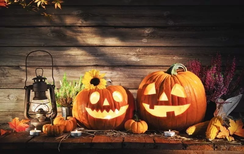Halloween pumpkin head jack-o-lantern on wooden background.