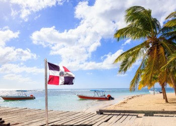 Caribbean beach and Dominican Republic flag on Saona island