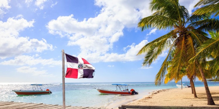 Caribbean beach and Dominican Republic flag on Saona island