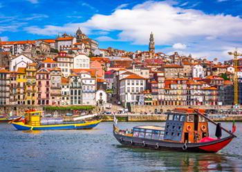 View of Porto Portugal, two colorful boats with the city behind them