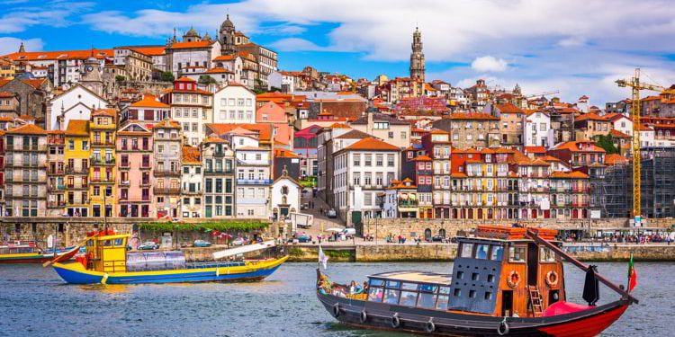 View of Porto Portugal, two colorful boats with the city behind them
