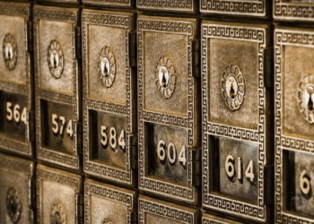 row of safety deposit boxes at a bank. the boxes are old fashioned and ornate
