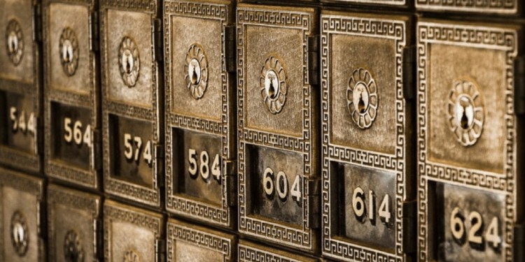 row of safety deposit boxes at a bank. the boxes are old fashioned and ornate