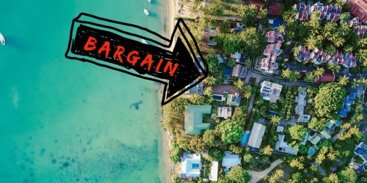 An aerial view down at homes along the beach with an arrow pointing to bargain properties.