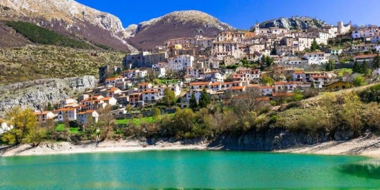 Abruzzo. Italy. italian town with mountains in background green water in front
