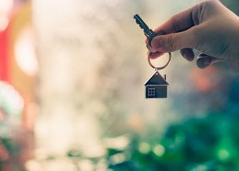 A hand holding a key with house keyring