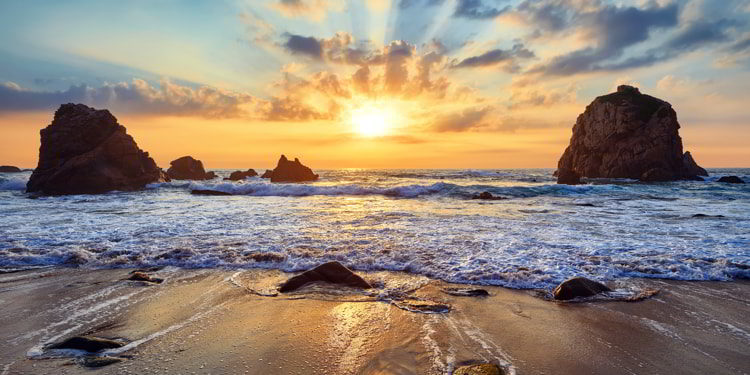 Sand beach among rocks during sunset in Portugal.