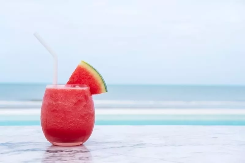 Watermelon smoothie on blue tropical beach.