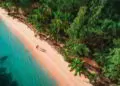 Two people walking on a white sand beach in Dominican Republic