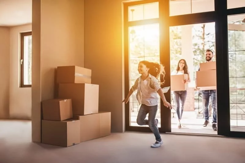 Happy family with cardboard boxes in new house at moving day.