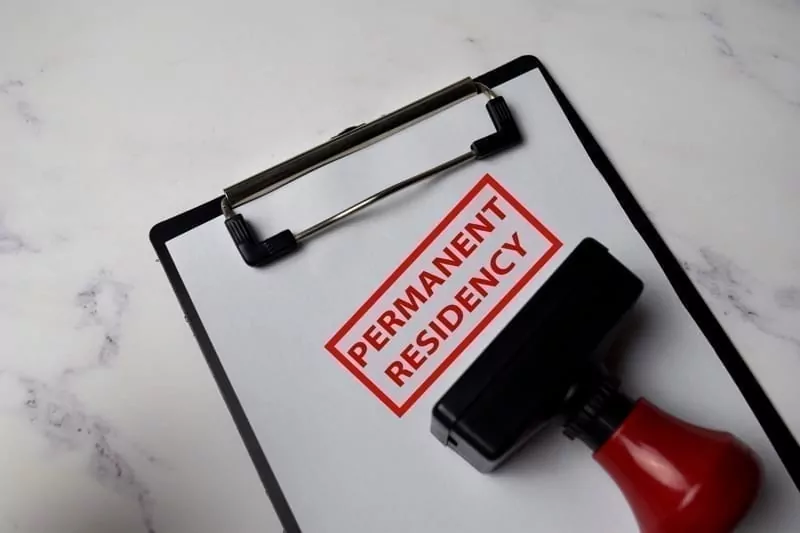 Red Handle Rubber Stamper and Permanent Residency text isolated on White Background.