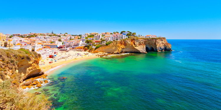 A town in the Algarve, Portugal right next to a bright blue ocean