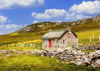 Traditional Irish thatched cottage and stone wall or fence on Achill Island in County Mayo Ireland