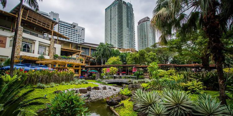 Gardens and skyscrapers at Greenbelt Park in the Philippines