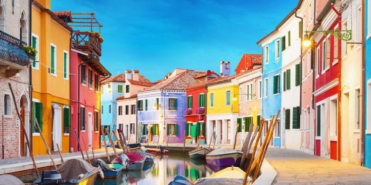 Colorful houses next to a canal with boats in Burano, Venice, Italy