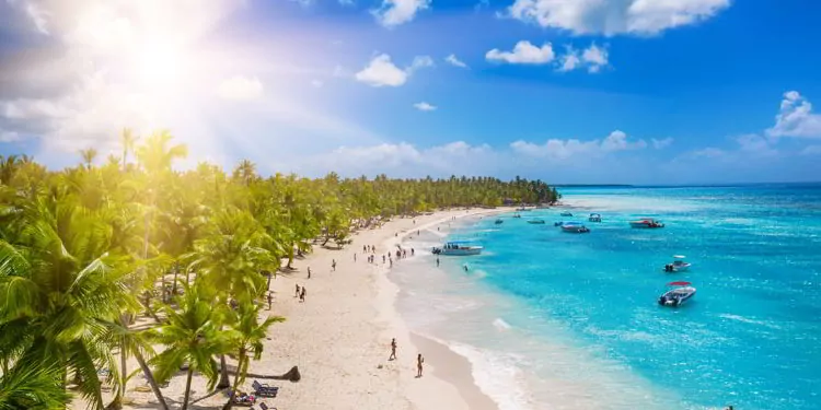 People enjoying a tropical Caribbean beach with white sands and clear waters