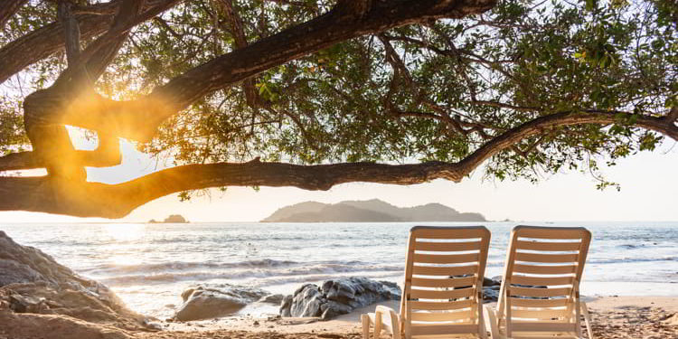Beach chairs facing the sea at sunset in Zihuatanejo, Mexico