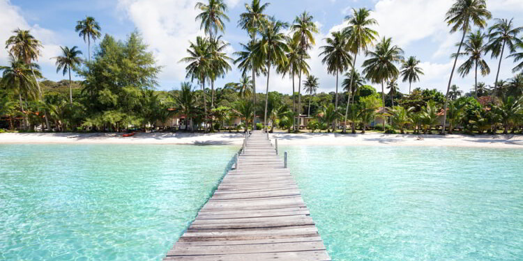 Paradise beach with turquoise water, wooden pier and tropical palm trees, summer holidays in Thailand. Plan Your Retirement Overseas