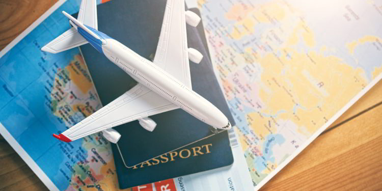 Plane model with world map, passports and tickets as airplane traveling and tickets booking concept