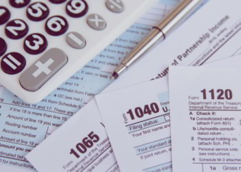 Calculator, pen on US tax form background