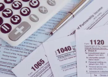 Calculator, pen on US tax form background