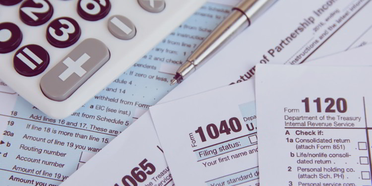 Calculator, pen on US tax form background