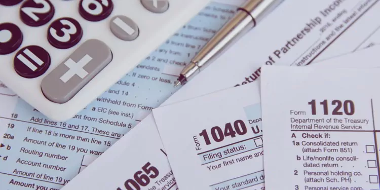Calculator, pen on US tax form background