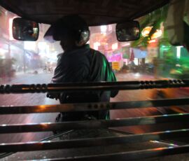 Night falls as a motorcycle rickshaw drives through the rain in Phnom Penh.